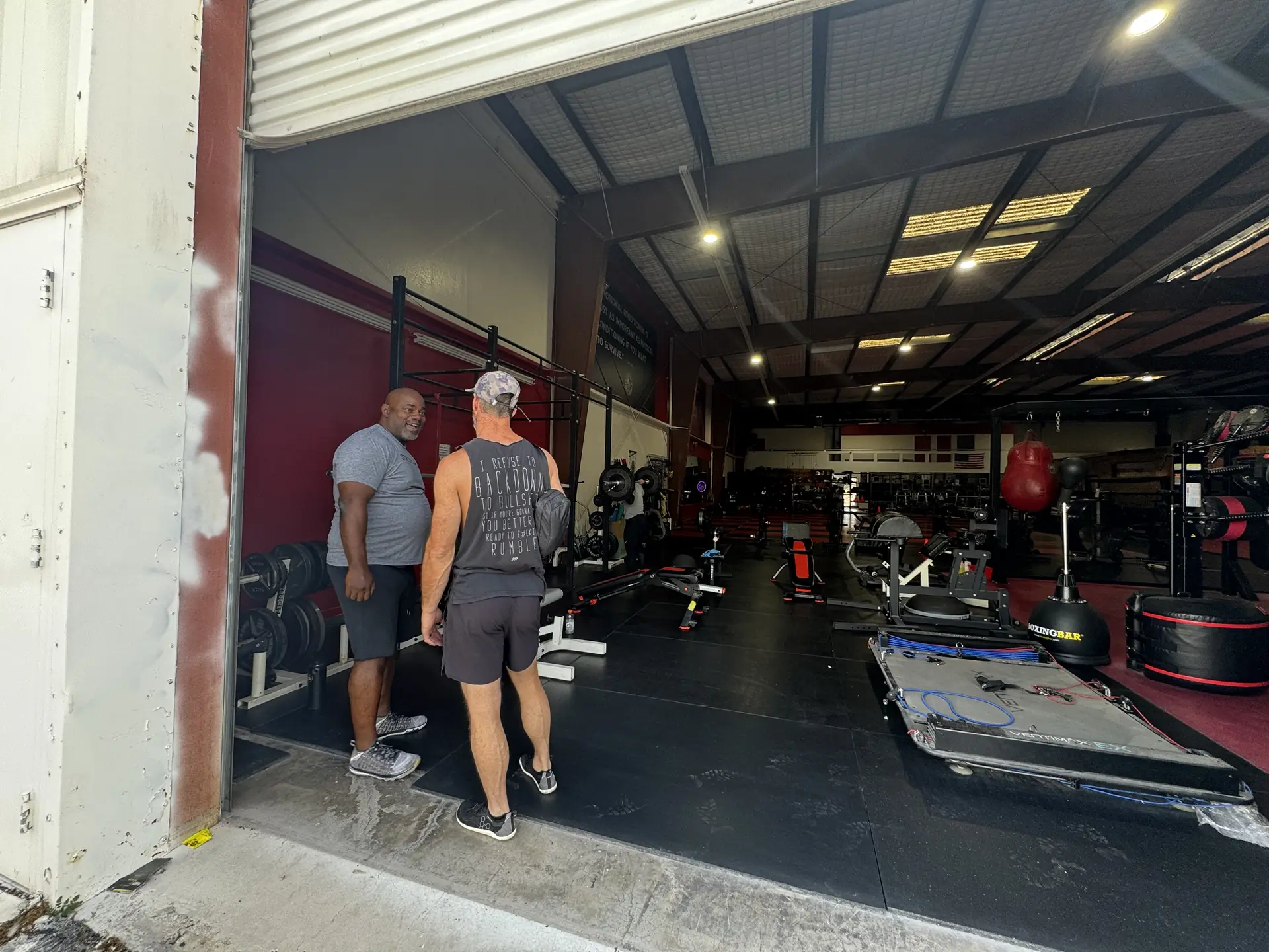 Coach Britt at Las Vegas Combat Academy gym entrance, with an STY-wearing visitor
