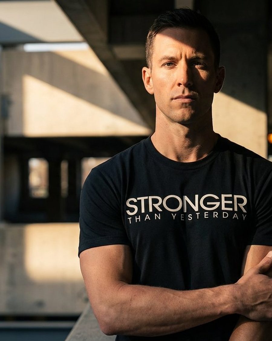 Logo tee, on model under industrial concrete columns at golden hour